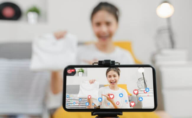 Mulher realizando live de vendas de camisetas, uma forma de monetizar no Instagram