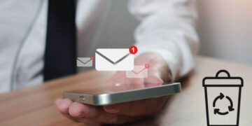 Foto de uma mão segurando um smartphone com ícones de mensagens e uma lixeira, representando a recuperação de mensagens apagadas no Instagram.