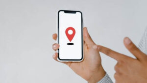 Foto de uma pessoa segurando um smartphone com um ícone de localização na tela, representando um tutorial sobre como criar uma localização no Instagram.