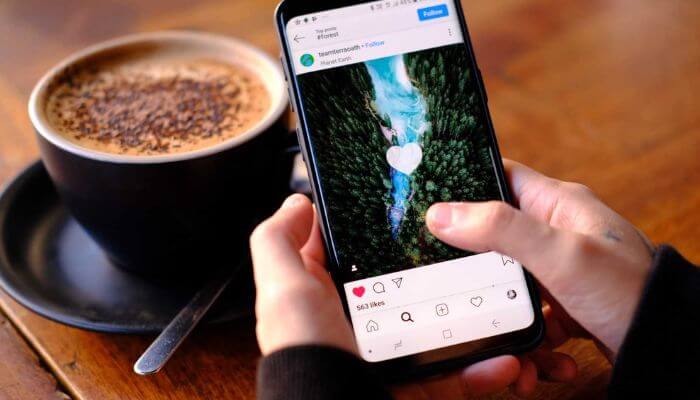 Pessoa interagindo com publicação no Instagram pelo celular