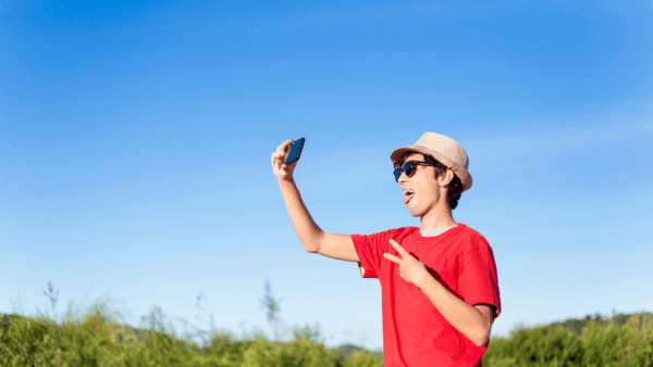 Influencer tirando foto instagram com um ceu azul ao fundo