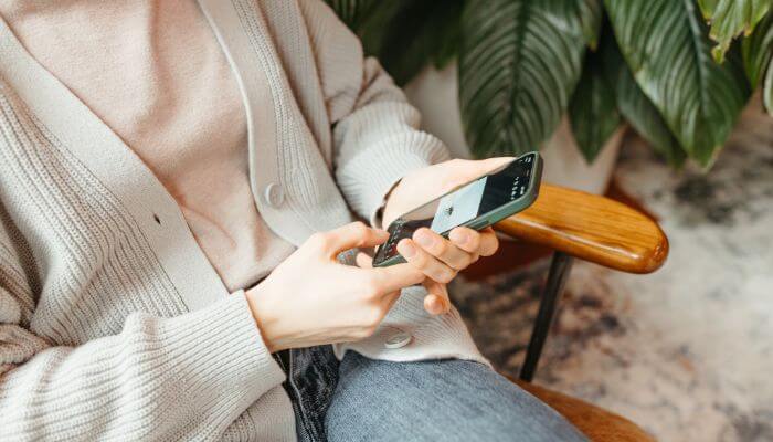 Foto de uma pessoa segurando um smartphone e navegando, representando um guia completo sobre o que é CTA no Instagram em 2024.