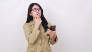 Foto de uma mulher pensativa segurando um smartphone, representando um guia rápido sobre como ver o histórico do Instagram em 2024.