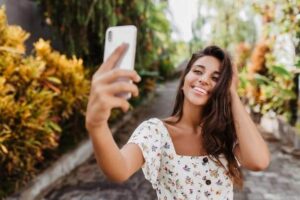 Mulher feliz sorrindo tirando foto selfie no jardim