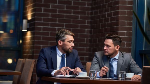 Investidores discutindo Meta One e próximos passos do conglomerado