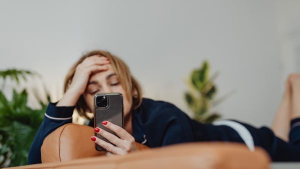 Usuária do Instagram preocupada enquanto assiste diversos Reels no Instagram em scroll infinito pelo celular